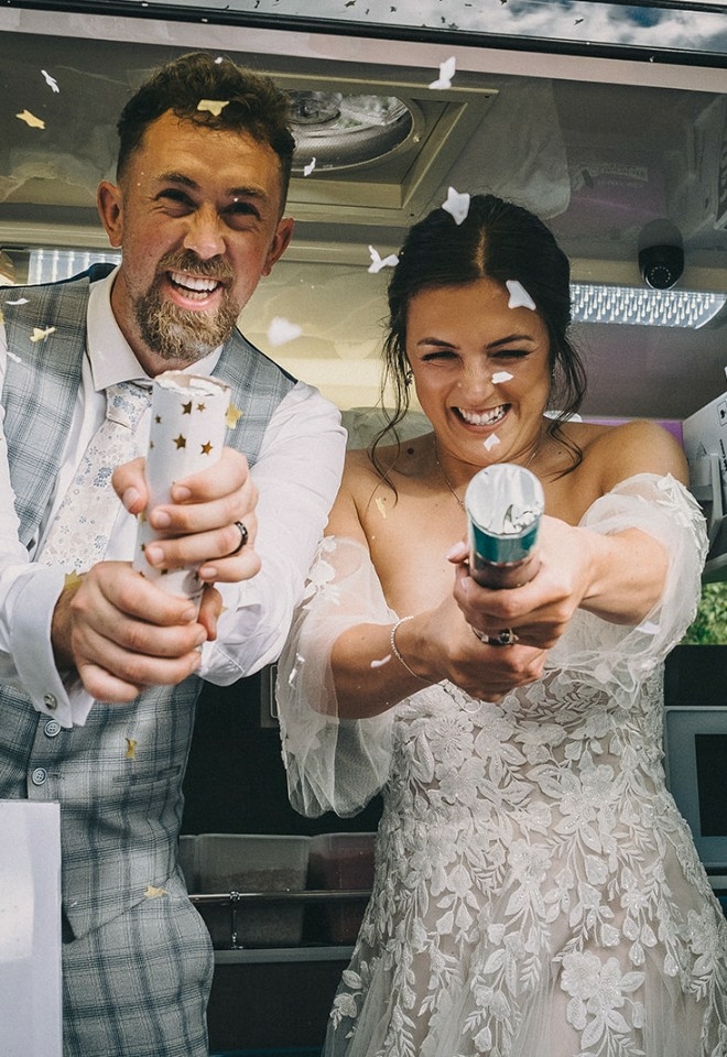 bride & groom in icecream van with party poppers at the Stables Wedding Farm