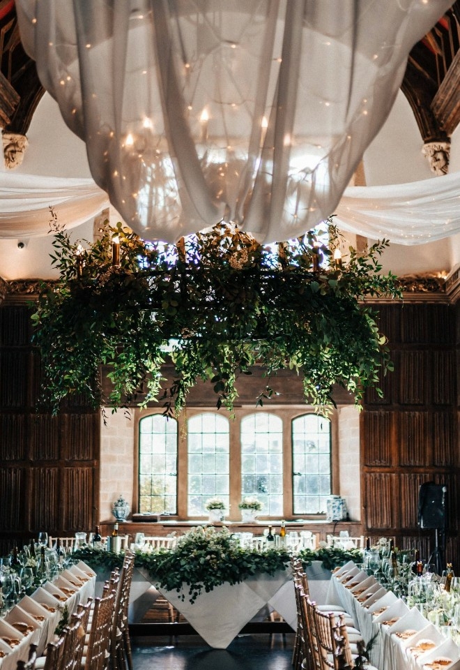 Close up baronial hall, wooden panelled, Ushaped wedding breakfast, floral chandelier
