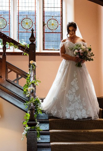 Bride and her grandmother descend the staircase at Coed Y Mwstwr Hotel, Bridgend