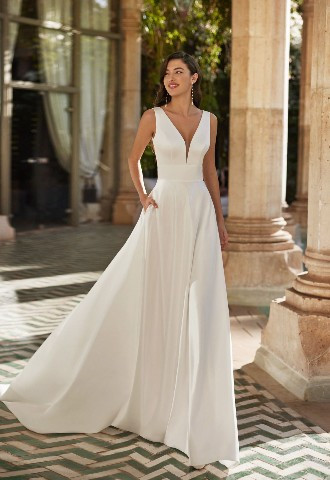 Ashley from Adriana Alier 2024 collection. Classic A-line wedding dress, made in satin V-neckline, corset back, & skirt with pockets.