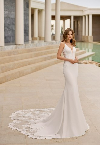 Venus by Rosa Clara simple straight cut perfectly offsets the elaborate lace bodice and elegant plunging neckline. Her back is shown open in a U shape, held by thin straps