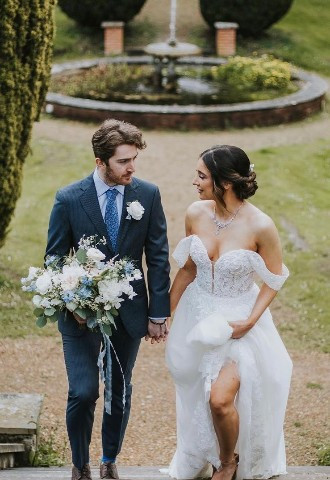 Bride and groom walking up the outside stairs at Hunton Park, Hertfordshire