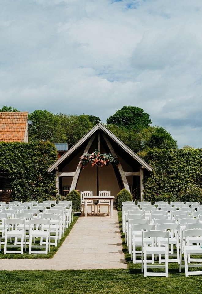 Outdoor wedding ceremony setting at Kingscote Barn