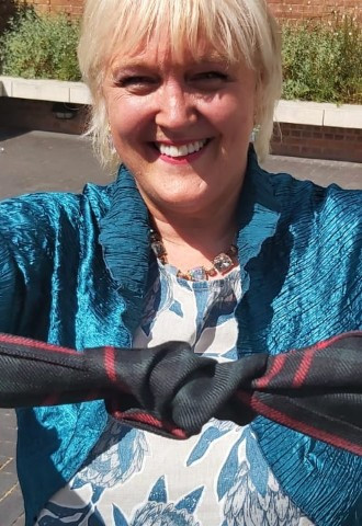 Janet holding out the perfect handfasting wrap and pull knot in tartan