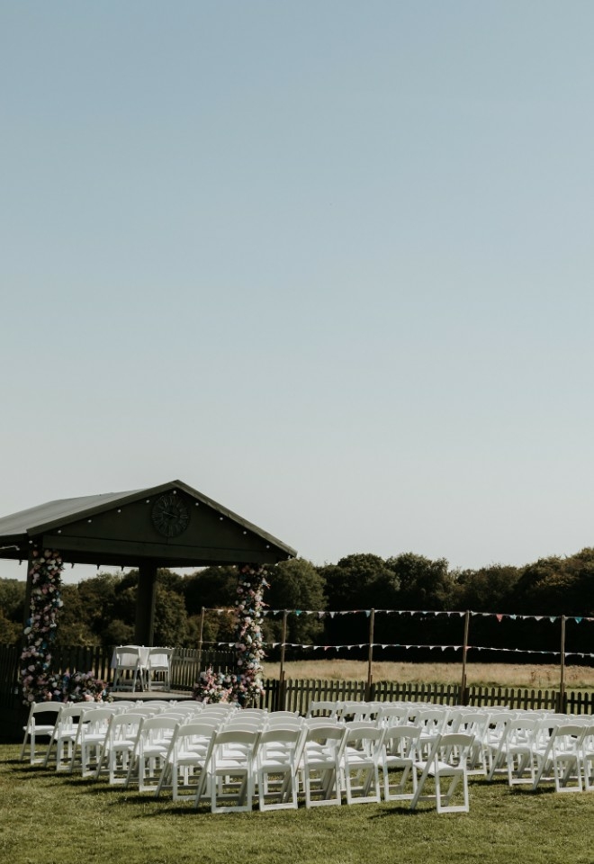 Outdoor wedding ceremony in the meadow at Monkton Barn wedding venue Buckinghamshire
