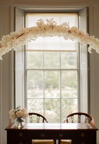 Ceremony room at Valentines mansion desk for signing the register with white hoop decorated in flowers as a centre piece