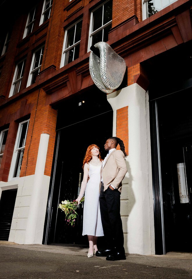 couple standing out front of the ministry under a discoball