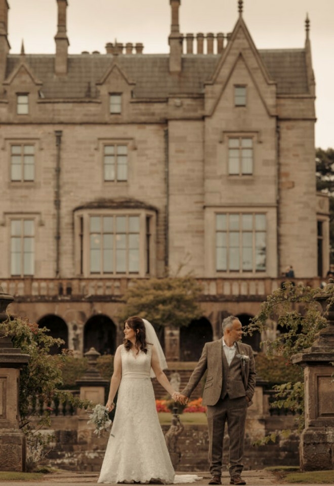 Bride and groom with Lilleshall House as the backdrop of their wedding photos