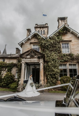 Bride arriving at Auchen Castle - romantic castle wedding venue in Scotland