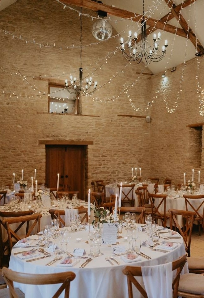 Pretty wedding breakfast setting inside Kingscote Barn