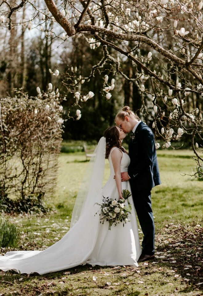 Couple by a blossom tree in the grounds