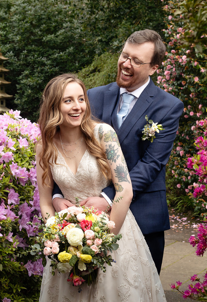 “Bride and groom at the Italian Villa Compton Acres Sandbanks Dorset surrounded by pink flowers”