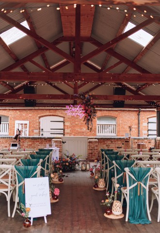 wedding ceremony set up in covered outdoor barn area