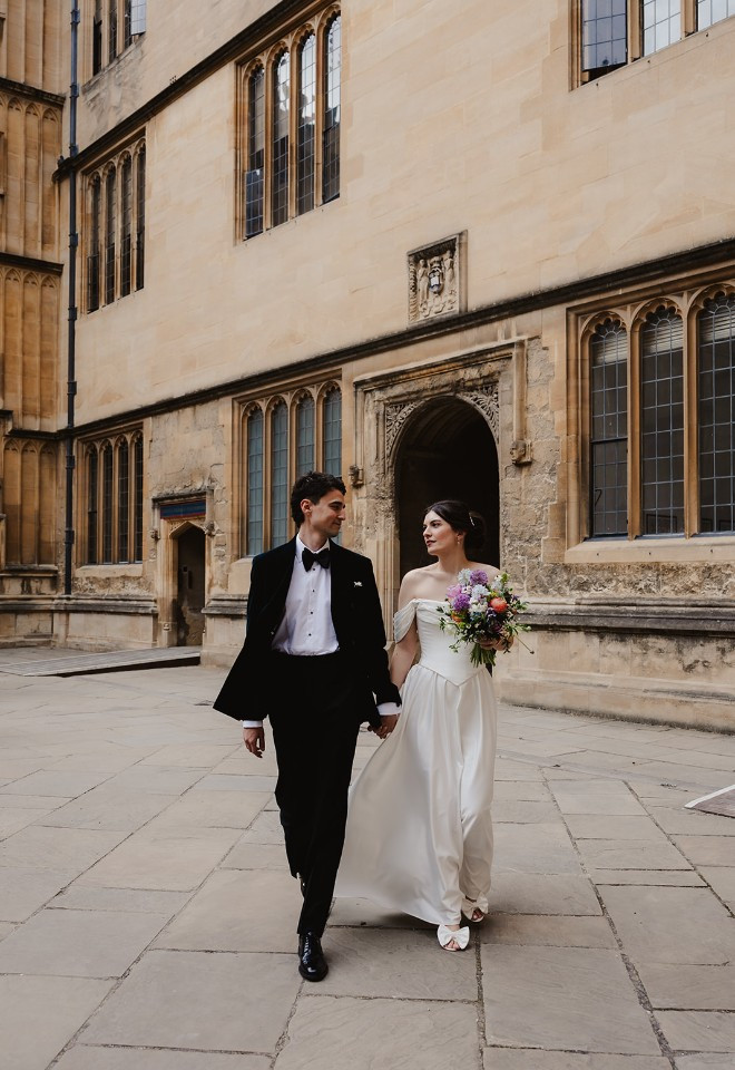 Bride and groom walking through the quad at the Bodleian library