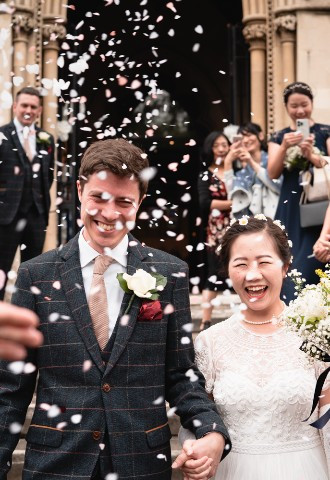 A bride and groom smiling as they exit the church