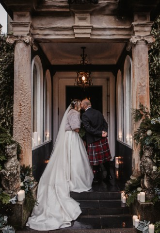 Wedding couple kissing on the steps at Auchen Castle - a romantic castle wedding venue in Scotland