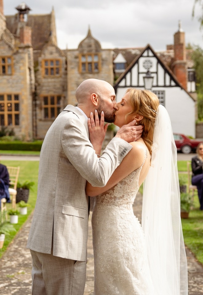 Bride and grooms first kiss in front of their guests at their outdoor wedding ceremony