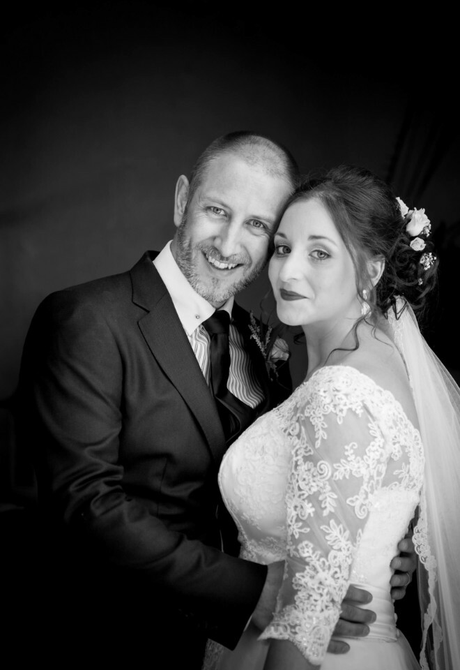 Smiling bride and groom in classic black and white wedding portrait