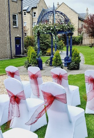 Outdoor ceremony with chairs and arch at The Fishers Hotel Wedding Venue