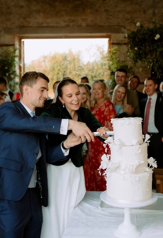 White wedding cake with trailing freesias and blossoms
