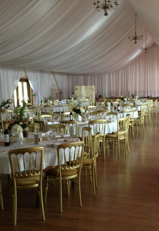 Wedding reception set up with gold chivari chairs at Duvale Priory