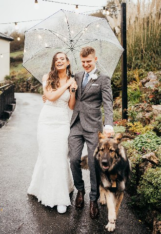 Devon Wedding Venue - Bride and groom walking their dog in the rain at Bickley Mill Inn, Devon