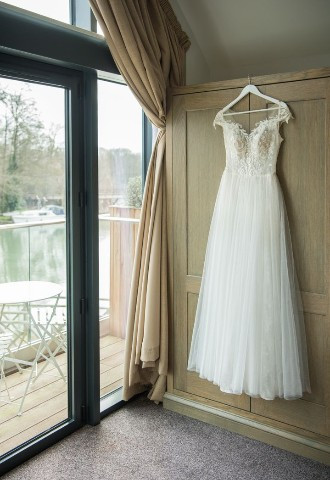 Wedding dress hanging up on wardrobe at The SWan at Streatley in Berkshire
