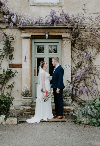 Wisteria Arch with Wedding couple by the Farmhouse at Widbrook Grange - a boutique wedding venue in The Cotswolds