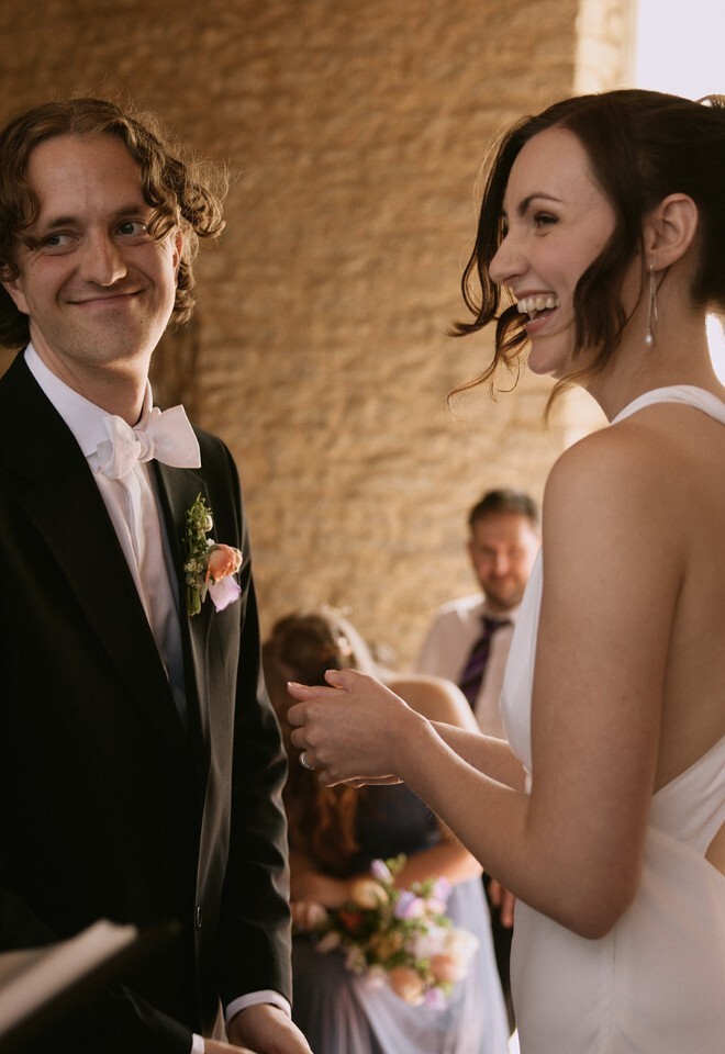 Bride and groom smiling at wedding celebrant in Stratton Court Barn ceremony