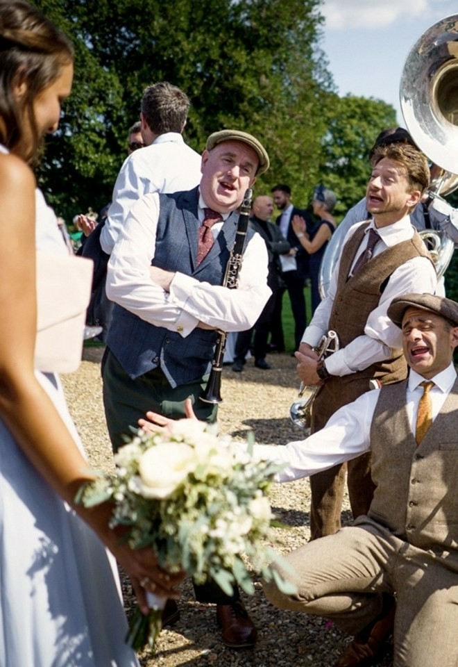 bride stood with musicians playing trombone, clarinet, trumpets at her wedding, music from alive network agency staffordshire