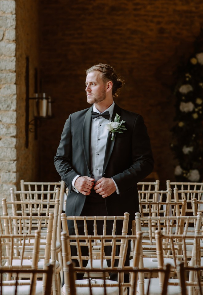 Groom waiting in ceremony room at Oxfordshire wedding barn