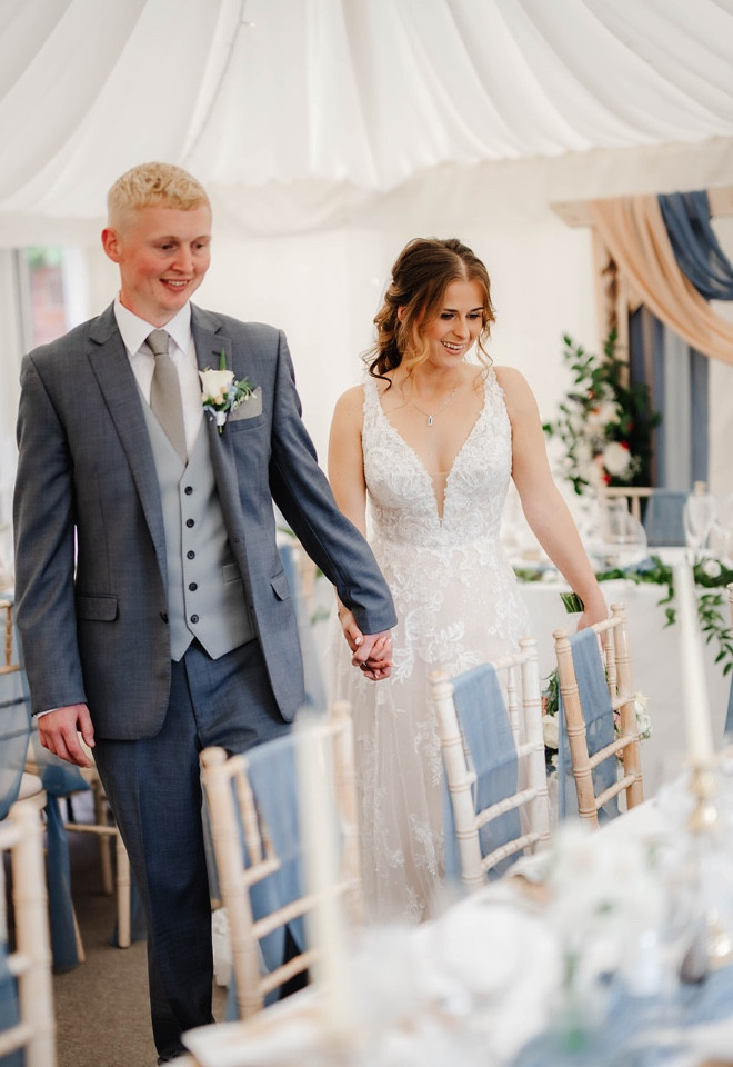 Newlyweds entering the beautifully dressed marquee for their wedding breakfast at The Cock O’Barton.