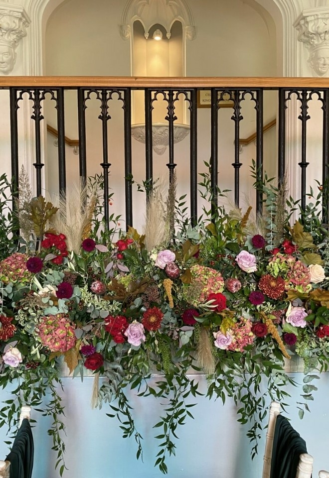 Red and pink flower banister display by hire heaven