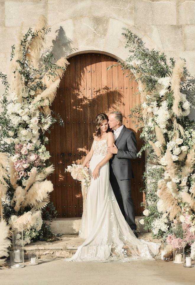 Mallorcan wedding bride and groom under arch of flowers at Sa Casa Bona by Stuart Wood