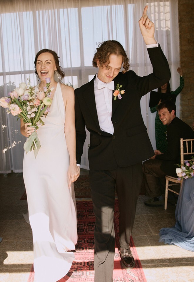 Fun couple dancing out of Buckinghamshire wedding ceremony