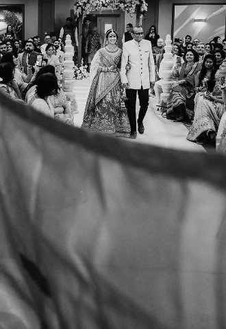Bride being escorted into her wedding ceremony at voco St Johns Solihull