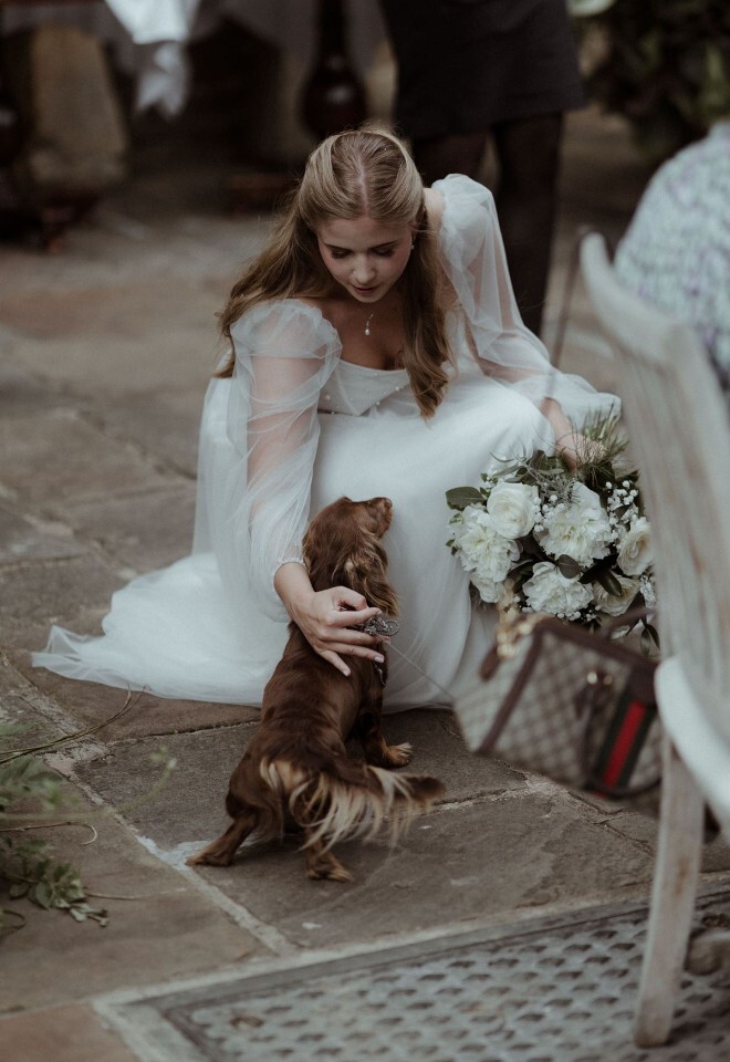 Brides fussing a dog at Buckland Manor 