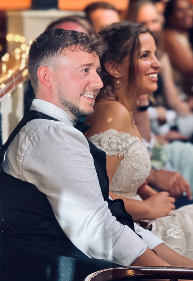 Bride and groom smiling during speeches