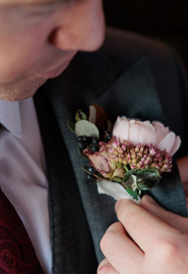 Buttonhole of sedum, eustsoma, logostrum berry, garden rose and foliage for autumn wedding at North Mymms Park