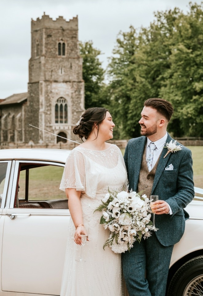 Copdock Hall neighbouring church behind wedding couple