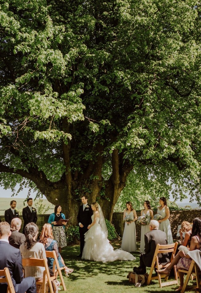 Outdoor wedding ceremony flowers beneath a tree by FLOWERS BY ANYA in Somerset