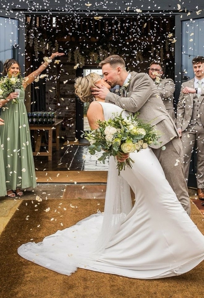 Hollywoood dip kiss in the entrance of the barn at burlton manor