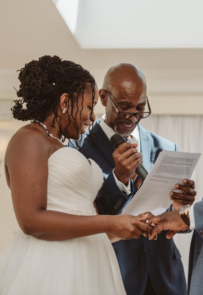 Couple exchanging rings and laughing during a ceremony by Chris Lowe Wedding Celebrant in Sittingbourne Kent