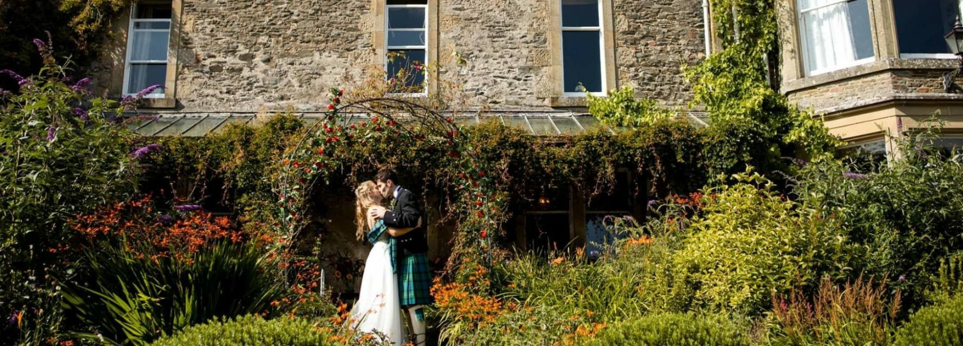 Couple kiss outside Kippilaw House wedding venue in Scottish Borders