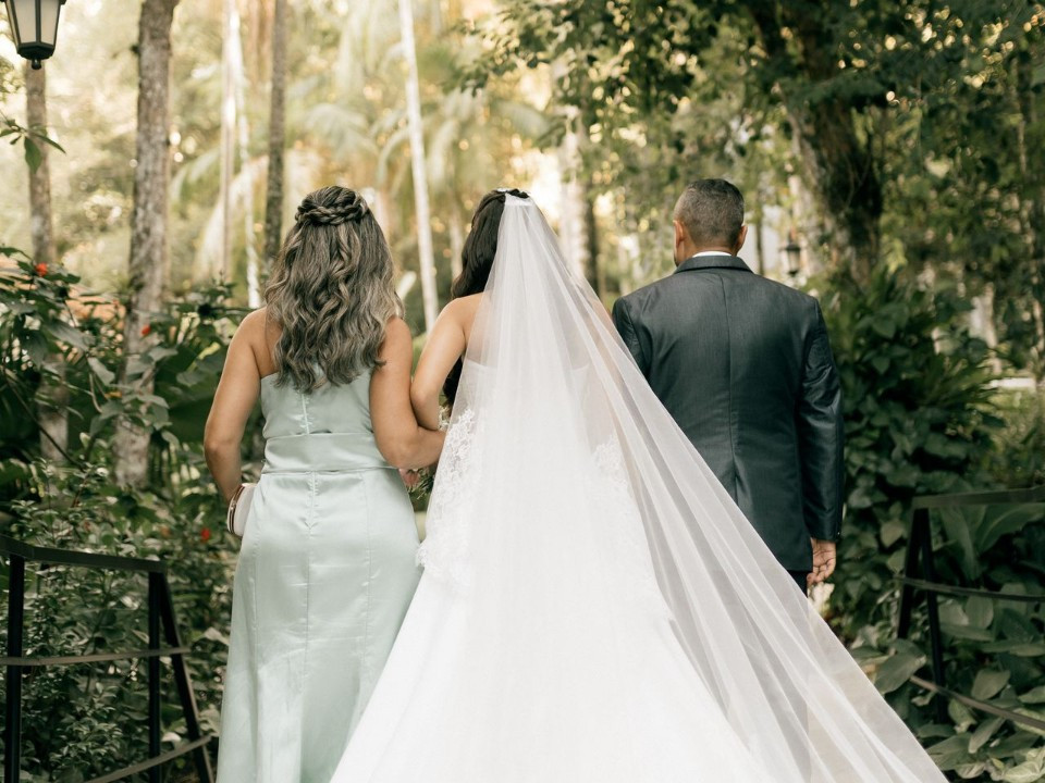 Bride walking with her parents before her wedding ceremony