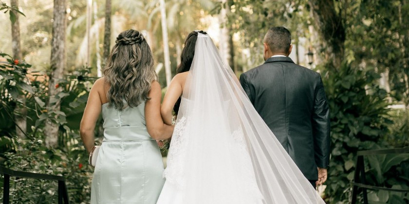 Bride walking with her parents before her wedding ceremony