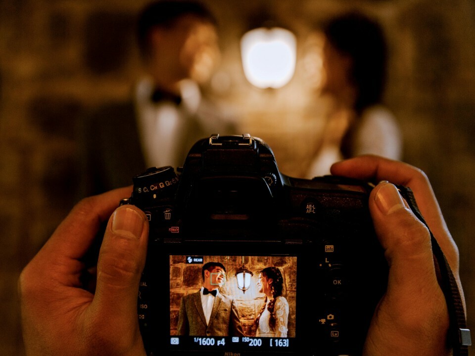 Wedding couple being photographed during their wedding day through a camera lens