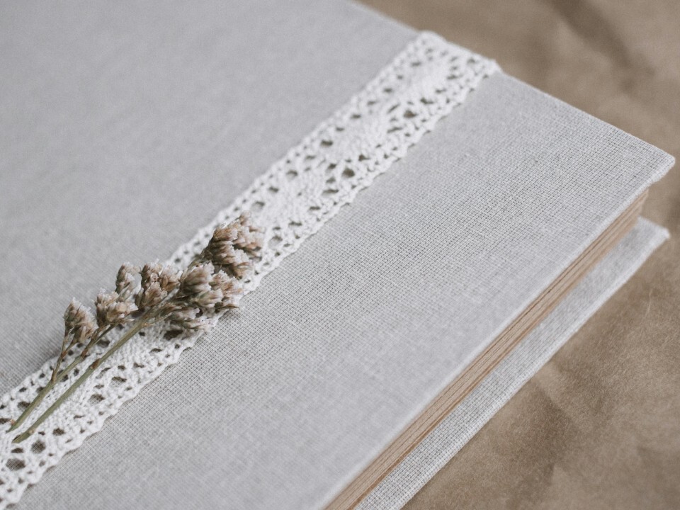 Wedding photo album with linen cover and lace detail.