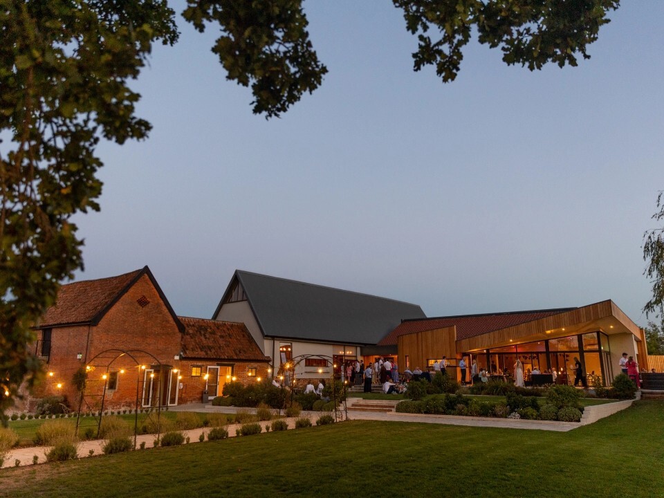 Outdoor of a barn area in the dark lit up with guests outside