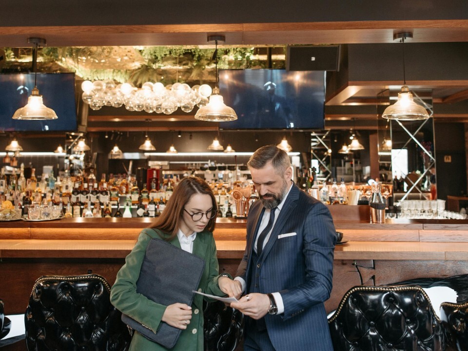 General manager of wedding venue with team member looking at paperwork next to the venues bar